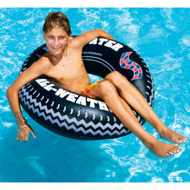 Boy floating on the inflatable monster tire ring