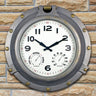 18” Silver Porthole Clock - faux brass screws and bolts around frame. Clock looks like a Porthole on a ship. shown hanging on a brick wall.