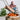 Person using a metal fire pit with flames, blurred background