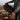 Person setting up a portable stove outdoors with a scenic background