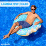 Young man lounging in a blue donut ring in the pool
