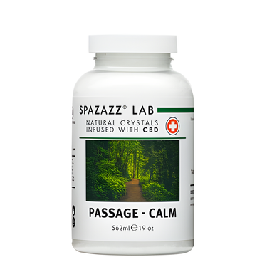 A white bottle displaying black text that says "Spazazz Lab Natural Crystals Infused With CBD: Passage - Calm". There is a image on the bottle depicting a walking path surrounded by lush greenery.