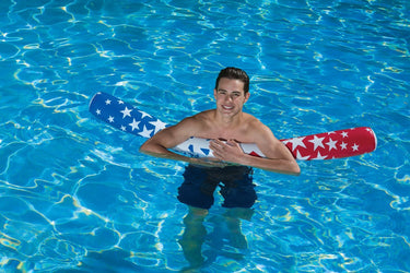Poolmaster American Stars Inflatable Noodle – 5 Feet of Floating Fun! - Young man holding onto it in the water.