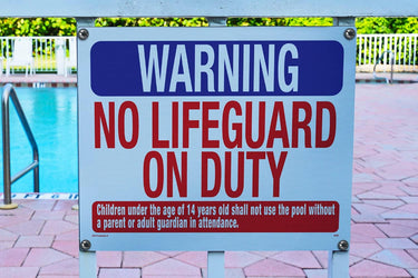 Warning No Lifeguard on Duty, Pool Sign. Red White & Blue. Hanging next to a pool.