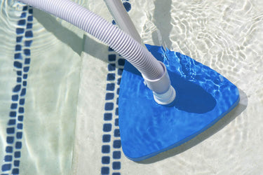 Triangle Vinyl Liner Vacuum Blue with white bristles on bottom and white plastic handle - hose and pole sold separately. - shown in water vacuuming a pool step