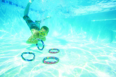 Active Xtreme Dive Rings - with fun designs. 2 blue, black and white and 2 red yellow and black. Shown child diving to retrieve the dive rings