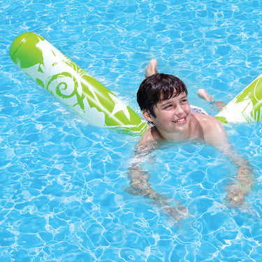 Young boy floating in the water with the Graffiti Inflatable Noodle.  Green with white stars and graffiti.