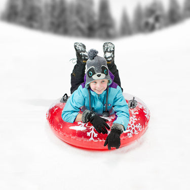 38" Red Tube with white snowflake design and black handles to hold on sliding down a hill in the snow. - Boy sliding down a hill on the Sno Cap