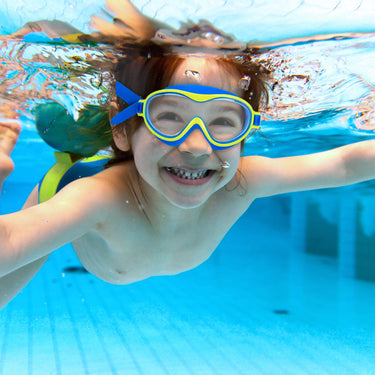 Little boy swimming underwater with eye mask on.  Blue with yellow trim.