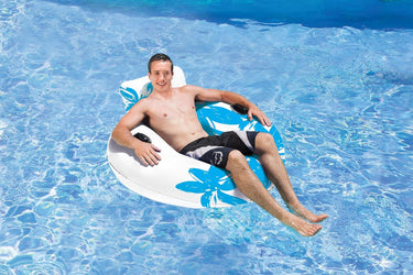 50" Blue Dreamy Days Lounge. White Tube with blue flowers on side and pillow. Young man floating on it in the swimming pool