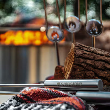 Sole Stove with fire pit and logs in the background