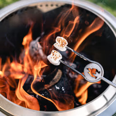 Toasted marshmallows on skewers over a campfire