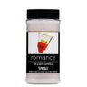 Bottle of 'romance strawberries n' champagne' spa and bath crystals with a black cap on a white background.