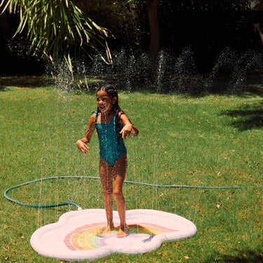 Childs Splash pad with rainbow and Hello summer text in grass with child playing