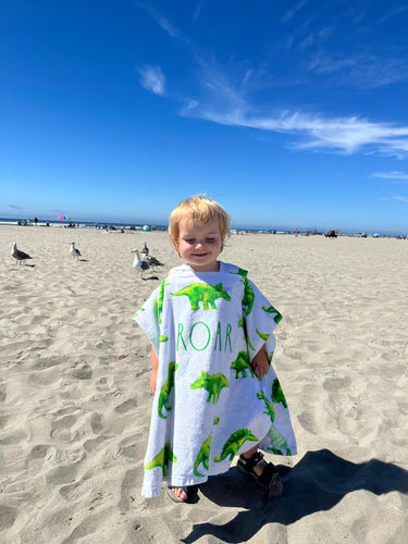 Little boy wearing the dinosaur hooded towel
