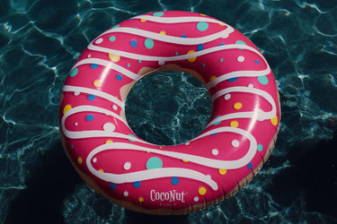 Sprinkled and Pink Glazed Donut Float in water