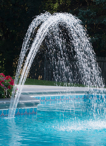 Pool fountain with water arching over a pool